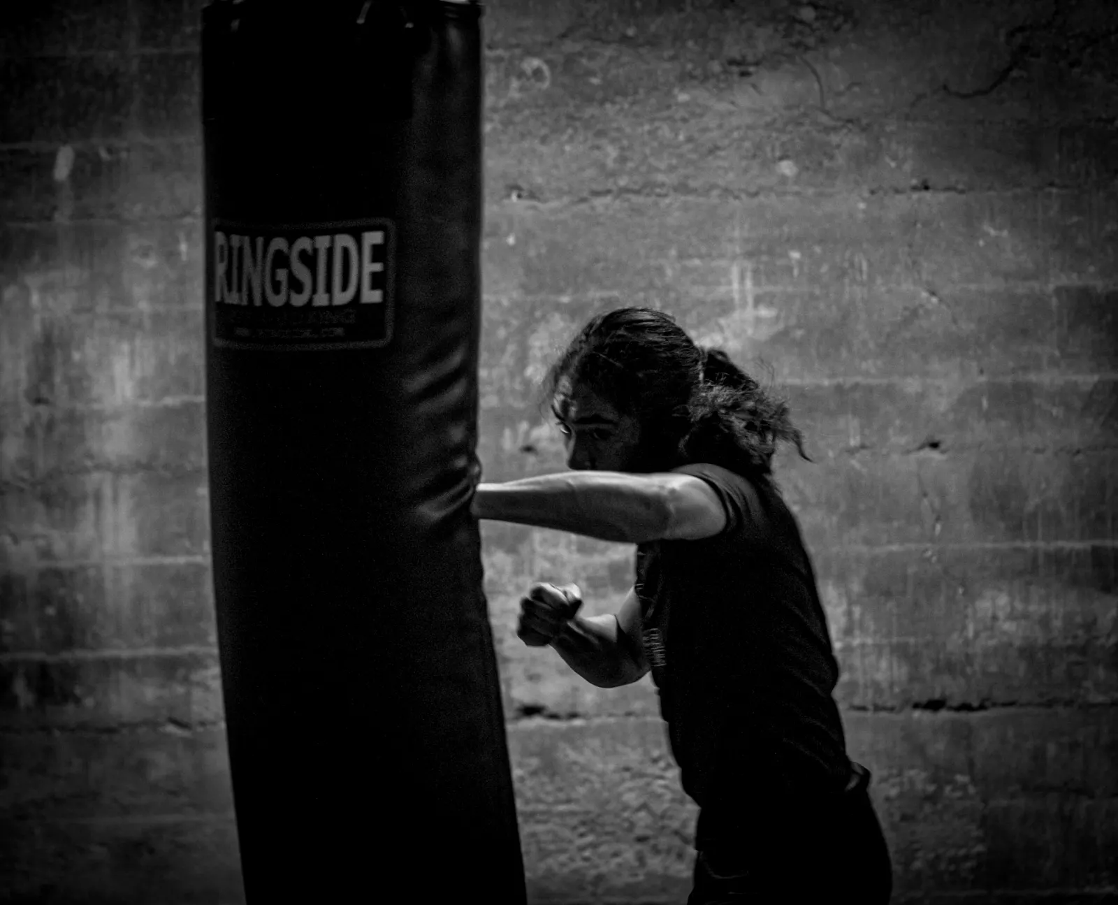 Kum torbasında kickboks antrenmanı yapan bir kadın sporcu